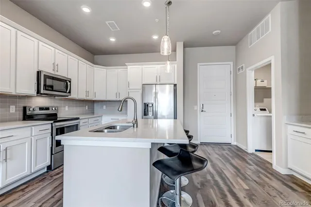 a kitchen with a sink stainless steel appliances and white cabinets