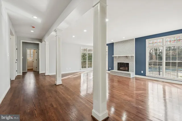 a view of a livingroom with wooden floor and a fireplace