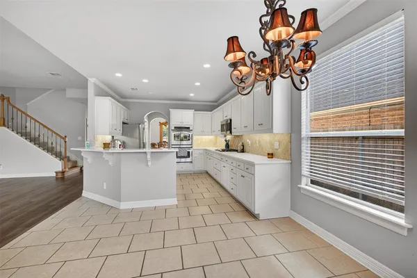 a view of kitchen with stainless steel appliances granite countertop lots of white cabinets