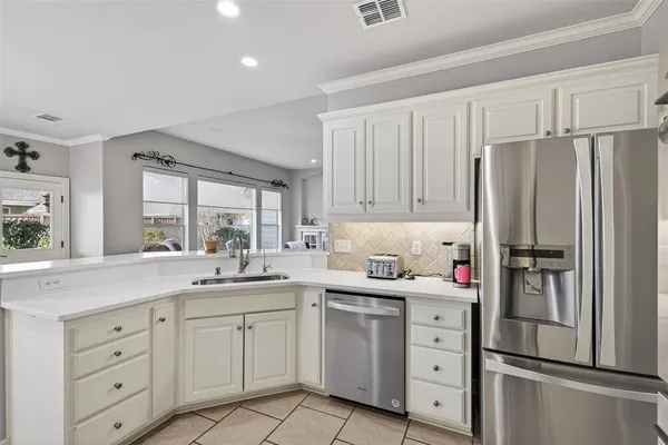 a kitchen with white cabinets white stainless steel appliances and sink
