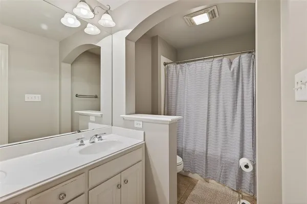 a bathroom with a sink vanity granite and toilet