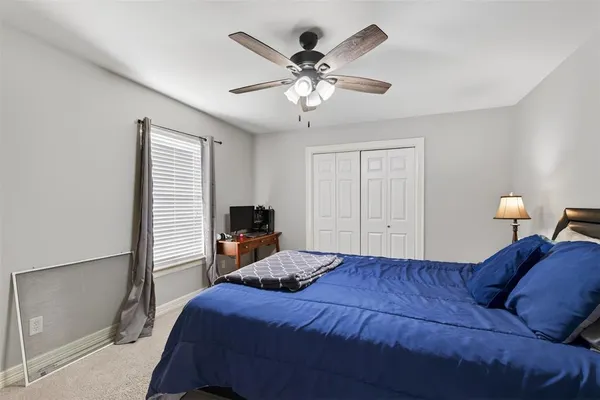 a bedroom with a large bed and a chandelier