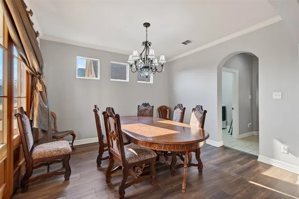 a view of a dining room with furniture a chandelier and wooden floor