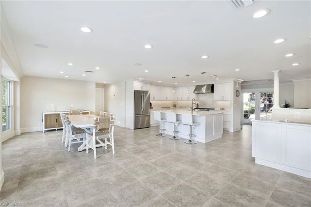 a large kitchen with a table and chairs
