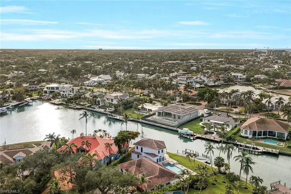 an aerial view of ocean and residential houses with outdoor space
