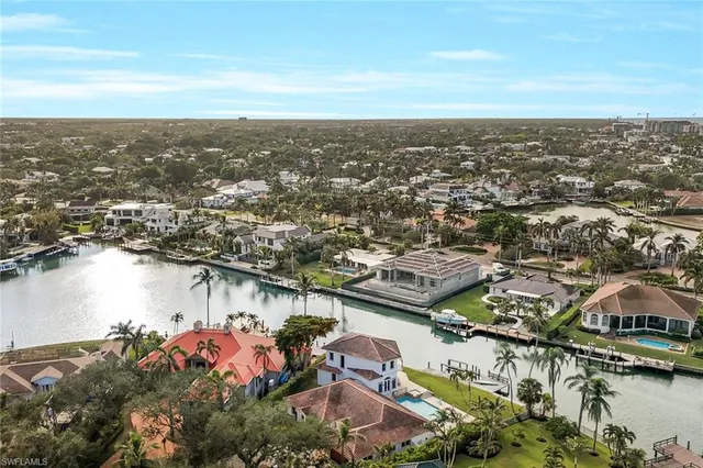 an aerial view of ocean and residential houses with outdoor space