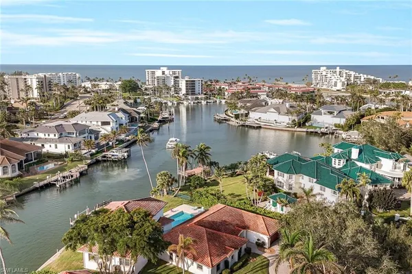an aerial view of ocean and residential houses with outdoor space