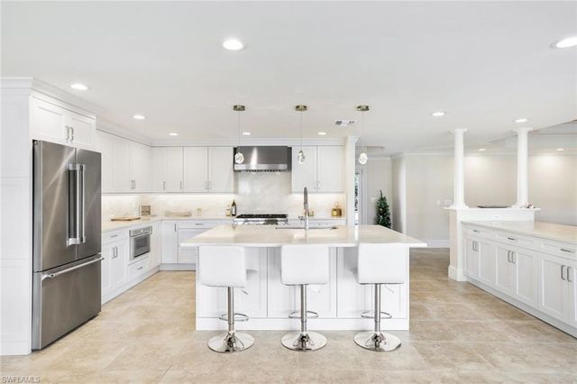 a kitchen with stainless steel appliances kitchen island granite countertop a sink and cabinets