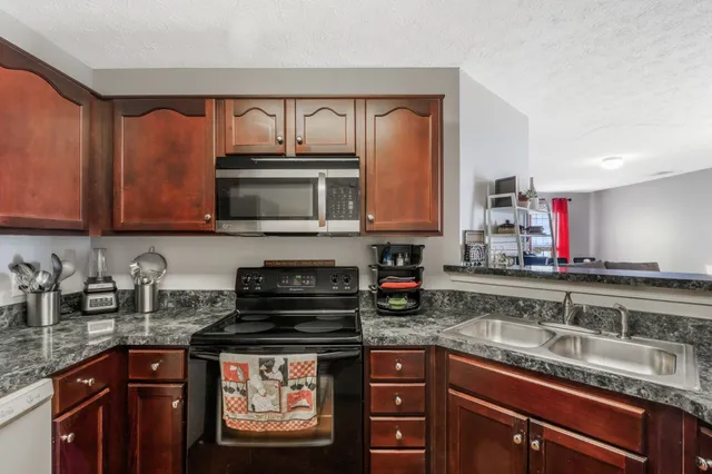 a kitchen with stainless steel appliances granite countertop a sink stove and cabinets
