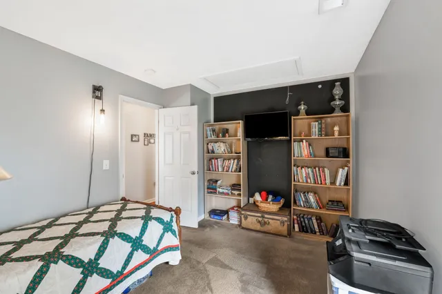 a bedroom with bed and a book shelf