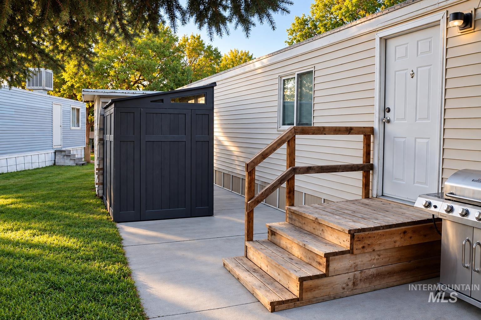 198 South Hills Road, Unit 52 Twin Falls, ID 83301 - Photo 16 of 22 Wood-finish siding, wooden deck with railing, concrete patio, and a modern privacy screen