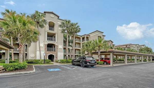 front view of a building with a lot of cars parked and a car parked in front of it