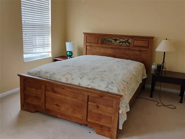 a bed sitting in a bedroom next to a window