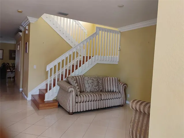 a living room with furniture and stairs