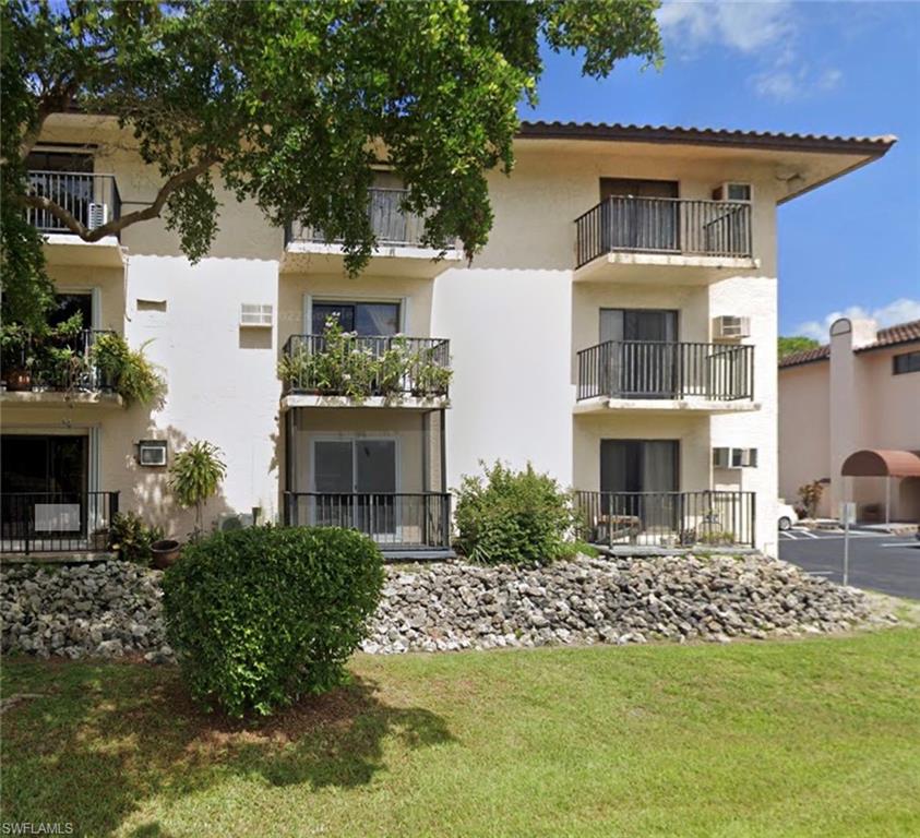 830 Wiggins Pass Road, Unit 10 Naples, FL 34110 - Photo 2 of 6 Back of property featuring a lawn and a balcony
