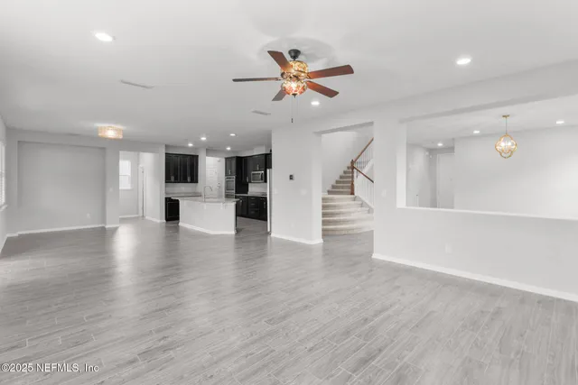 a kitchen with stainless steel appliances granite countertop a refrigerator a sink a stove and oven