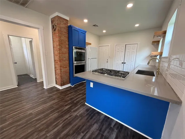 a kitchen with stainless steel appliances granite countertop a stove a sink and a refrigerator