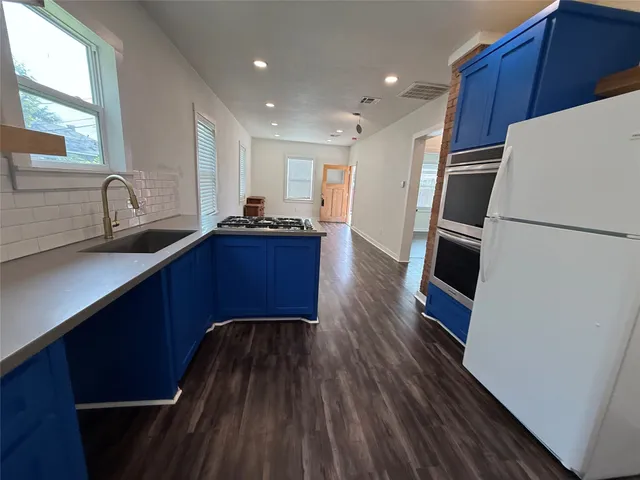 a kitchen with wooden floors and wooden cabinets