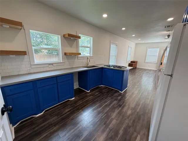 a kitchen with wooden floors and wooden cabinets