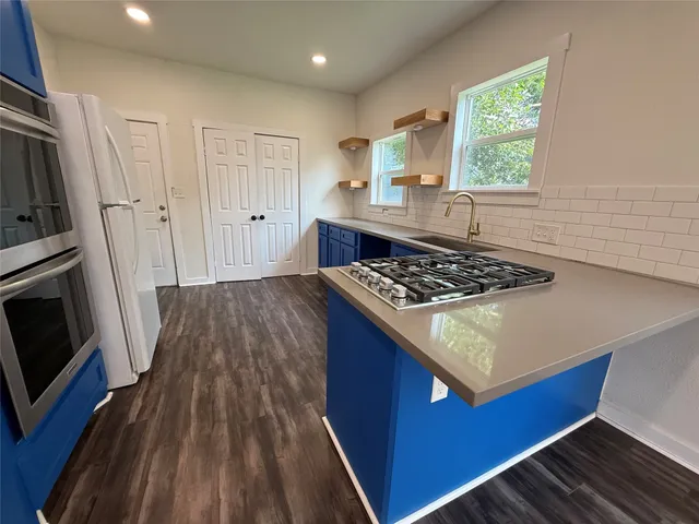 a kitchen with a stove a sink and a refrigerator