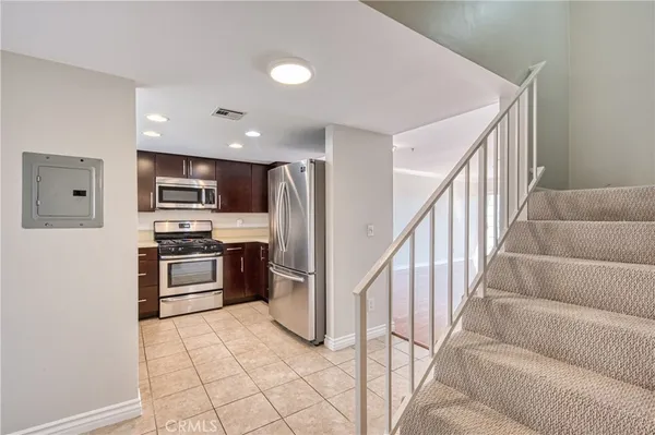 a kitchen with stainless steel appliances kitchen island granite countertop a refrigerator and a stove top oven