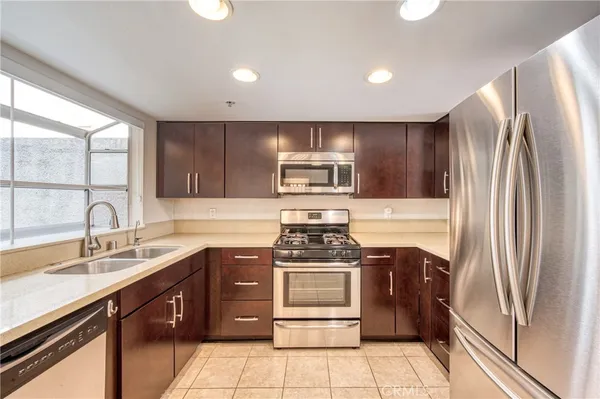 a kitchen with stainless steel appliances granite countertop a stove a sink and a refrigerator