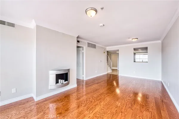 a view of empty room with wooden floor and fireplace