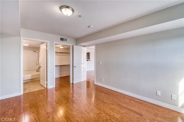 a view of empty room with wooden floor