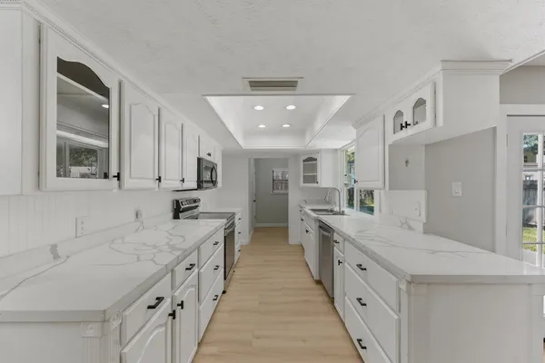 a large white kitchen with stainless steel appliances