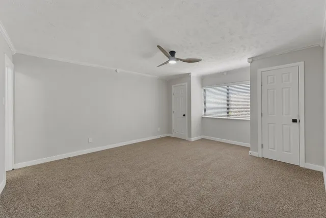 a view of an empty room and a ceiling fan