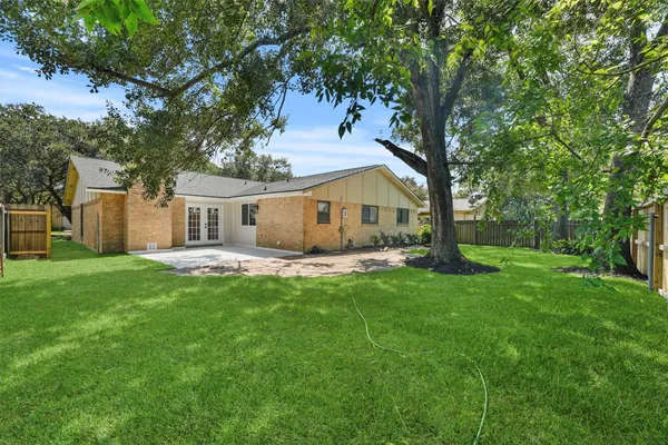 a view of a house with backyard and a tree