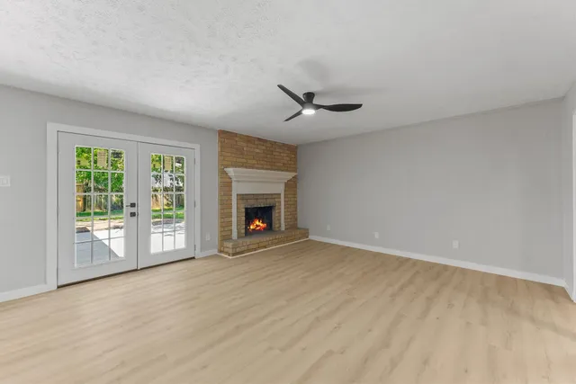 a view of an empty room with a fireplace and a window