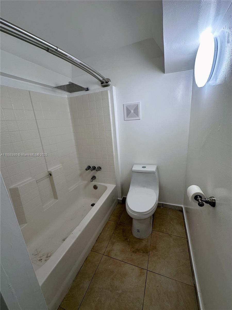 9064 Collins Avenue, Unit C19 Surfside, FL 33154 - Photo 15 of 17 a bathroom with a toilet and a bathtub