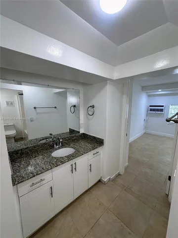 a bathroom with a granite countertop sink and a mirror
