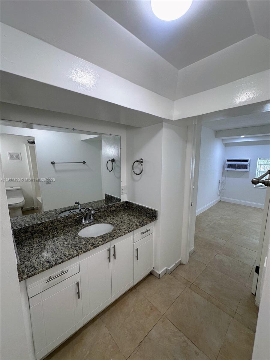 9064 Collins Avenue, Unit C19 Surfside, FL 33154 - Photo 17 of 17 a bathroom with a granite countertop sink and a mirror