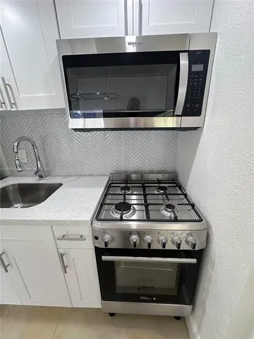 a stove top oven sitting inside of a kitchen