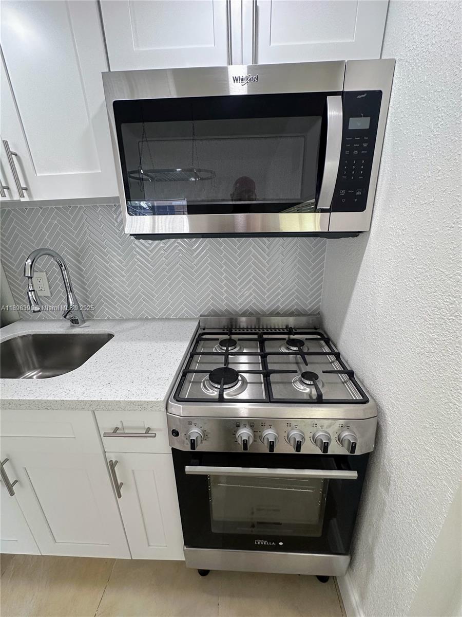 9064 Collins Avenue, Unit C19 Surfside, FL 33154 - Photo 3 of 17 a stove top oven sitting inside of a kitchen