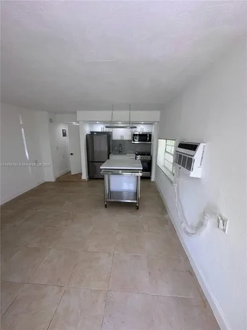 a living room with furniture and a kitchen
