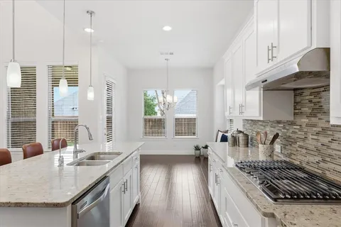 a kitchen with sink stove and cabinets