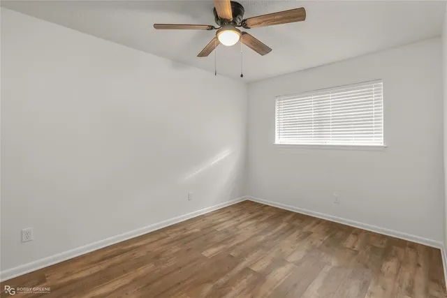 an empty room with a window and a fan