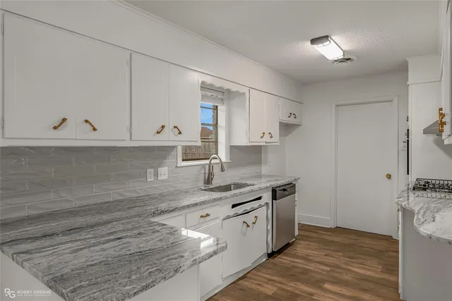 a kitchen with stainless steel appliances granite countertop a sink stove and cabinets