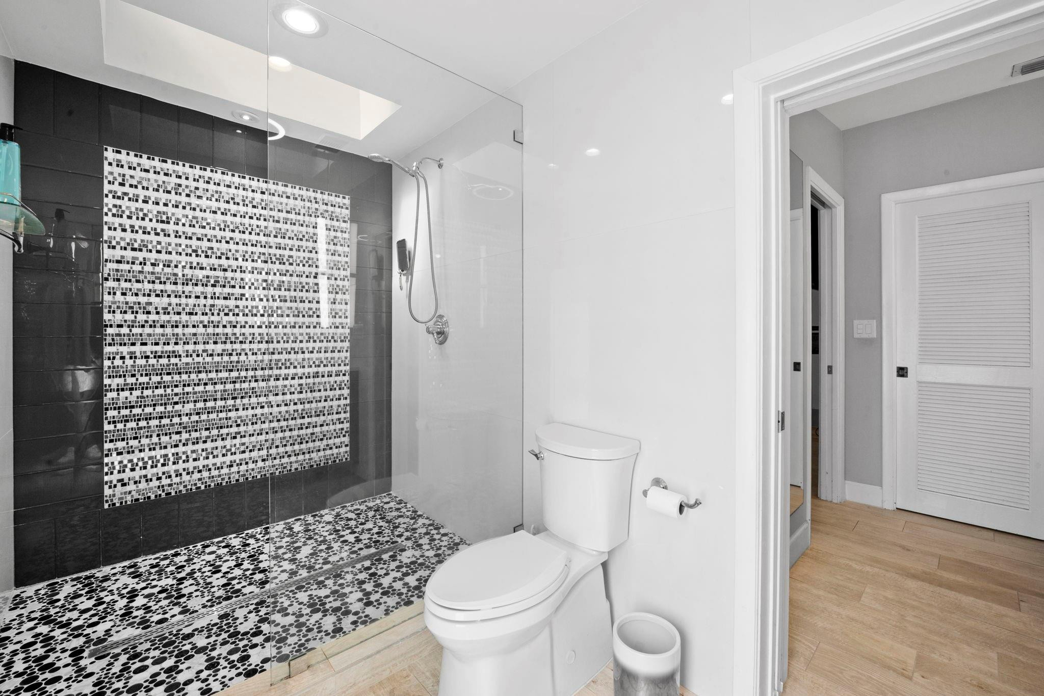 2675 Northeast 24th Street Lighthouse Point, FL 33064 - Photo 17 of 48 a bathroom with a toilet and a shower