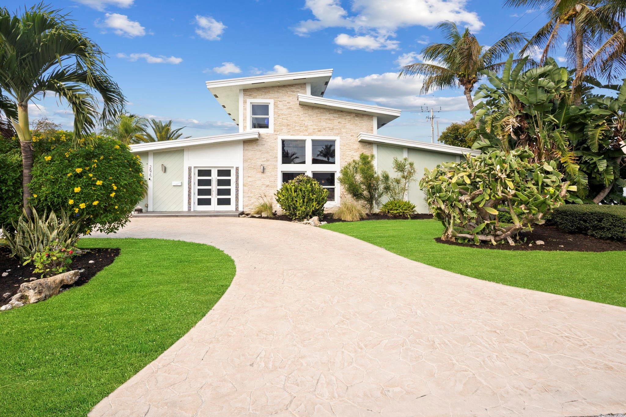 2675 Northeast 24th Street Lighthouse Point, FL 33064 - Photo 20 of 48 a front view of a house with a garden and yard