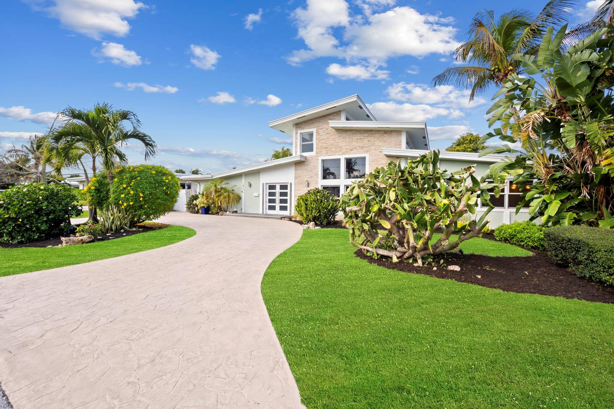 2675 Northeast 24th Street Lighthouse Point, FL 33064 - Photo 21 of 48 a front view of a house with a yard