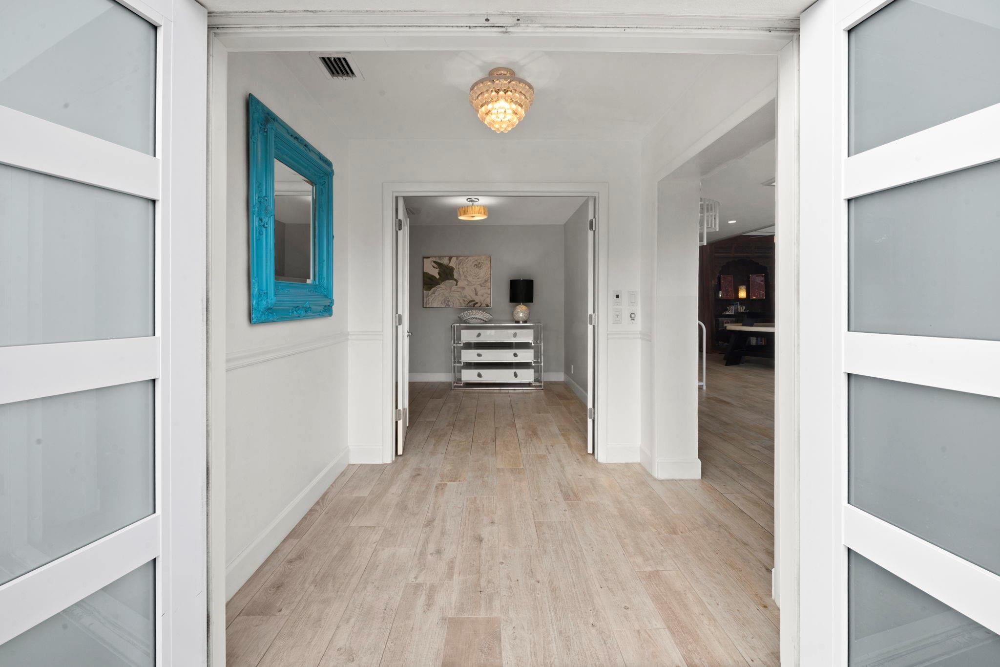 2675 Northeast 24th Street Lighthouse Point, FL 33064 - Photo 22 of 48 a view of a hallway view with wooden floor and staircase