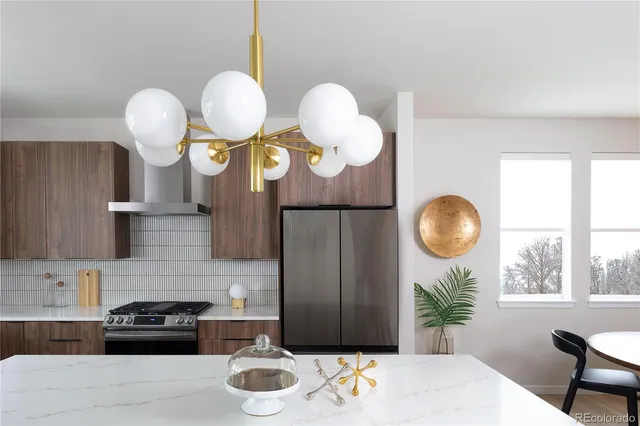 a kitchen with stainless steel appliances granite countertop a stove a sink a dining table and chairs with wooden floor