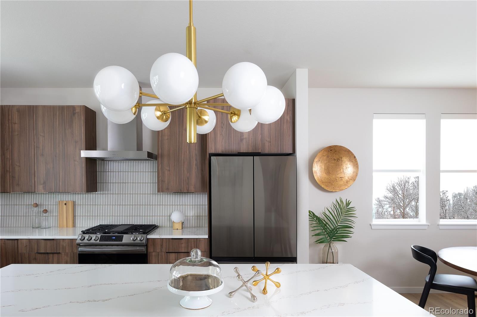 14472 Tranquil Court Morrison, CO 80465 - Photo 11 of 13 a kitchen with stainless steel appliances granite countertop a stove a sink a dining table and chairs with wooden floor