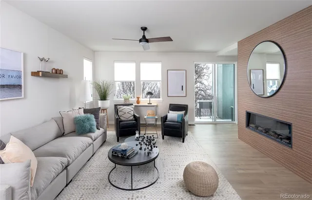 a living room with furniture a fireplace and a large window