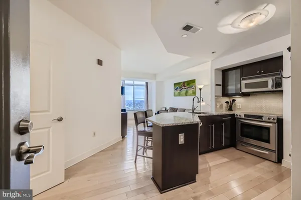 a kitchen with stainless steel appliances granite countertop a stove top oven a sink dishwasher and a refrigerator