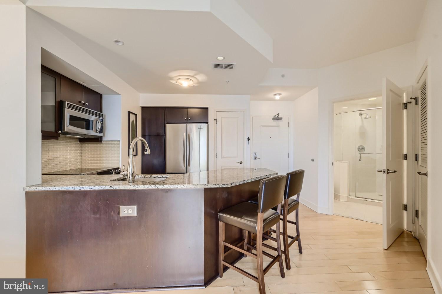 675 President Street, Unit 2107 Baltimore, MD 21202 - Photo 14 of 39 a kitchen with stainless steel appliances granite countertop a kitchen island hardwood floor and a sink